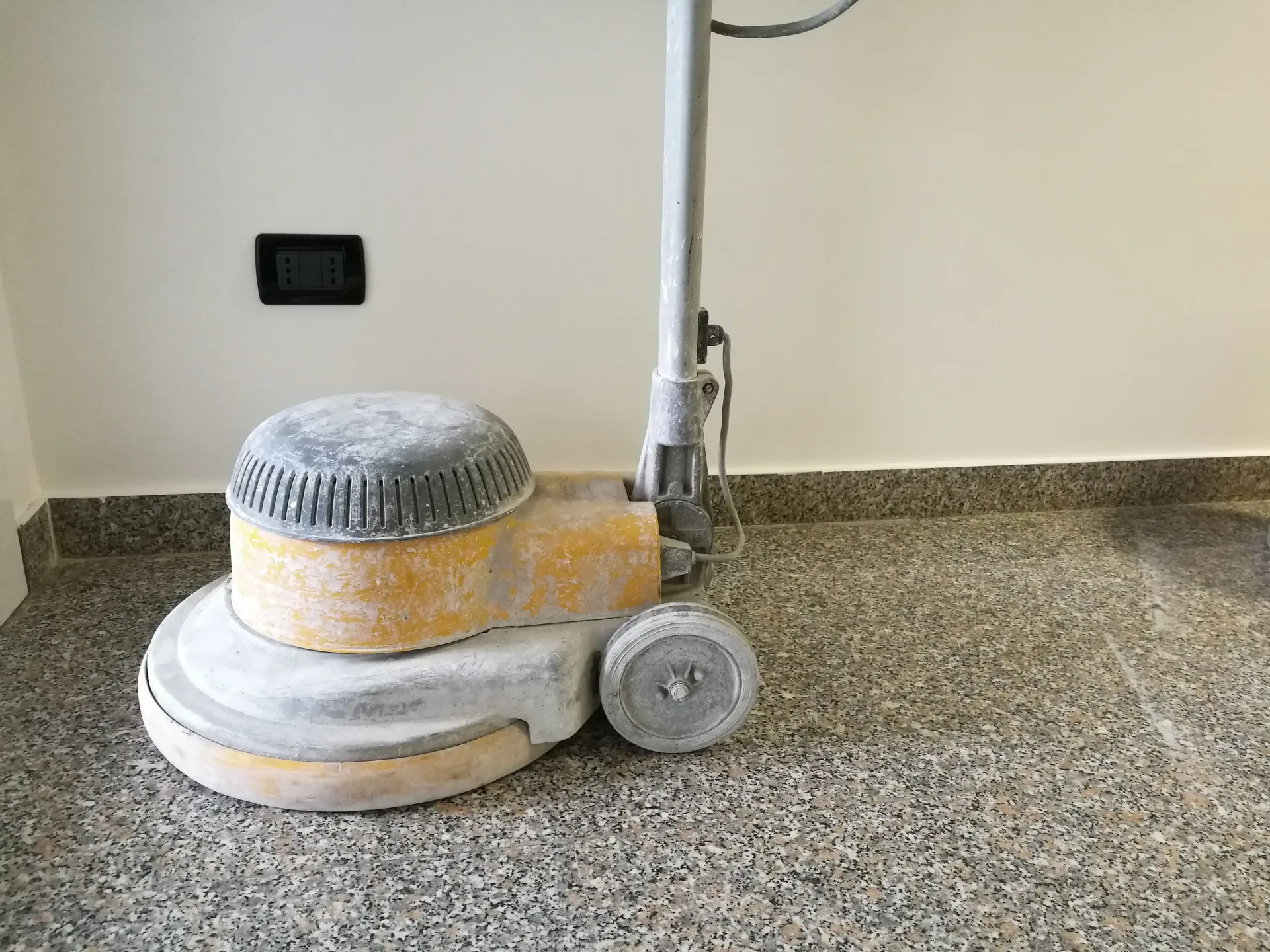 A machine is sitting on a granite floor in a room.