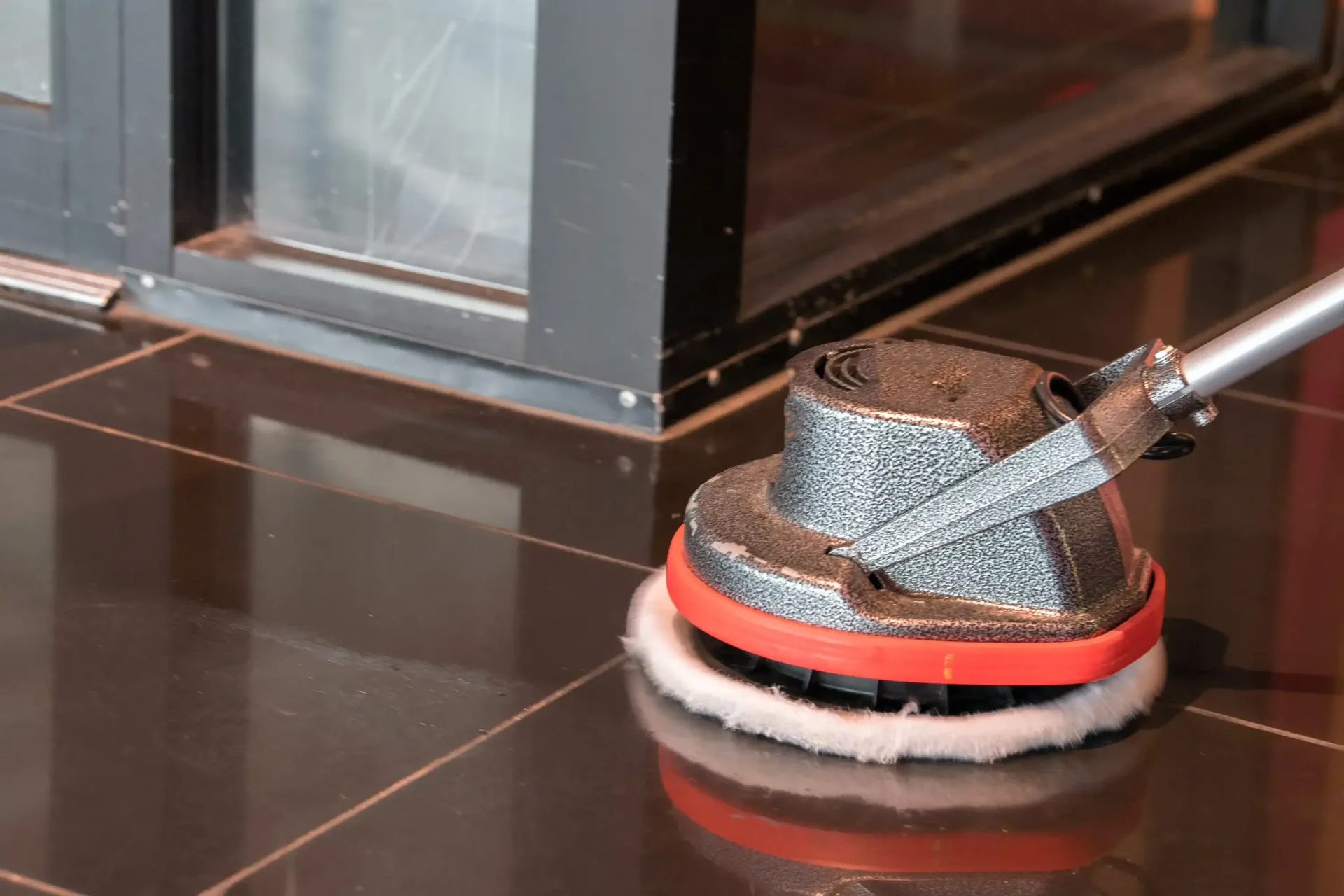A person is cleaning a tiled floor with a mop.