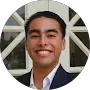 A man in a suit and white shirt is smiling in a circle.